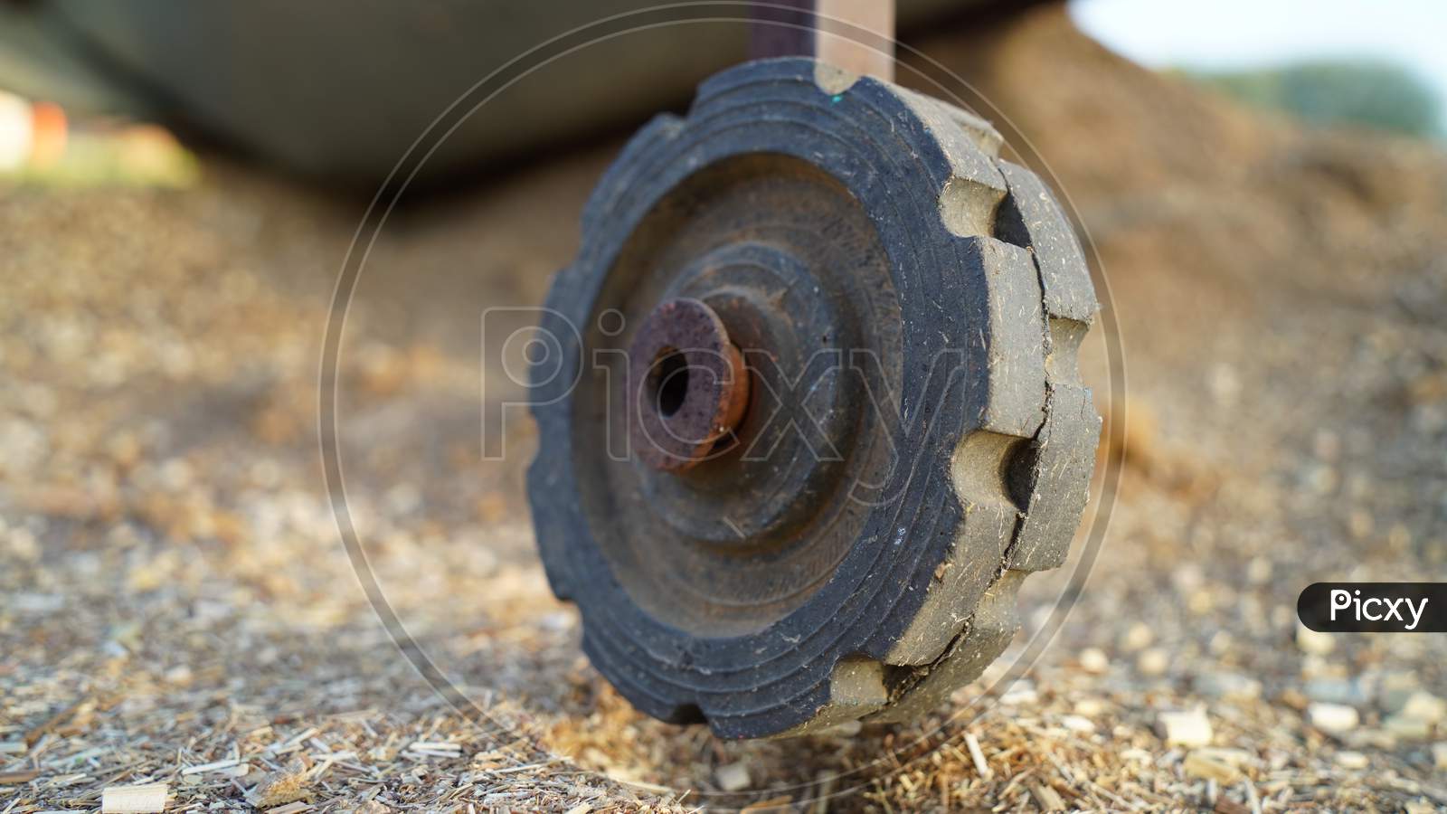Old Rustic Wheel Of Fodder Harvesting And Cleaning Machine. Black Wheel Of Machine In Rustic Stage. Plastic Wheel Closeup.