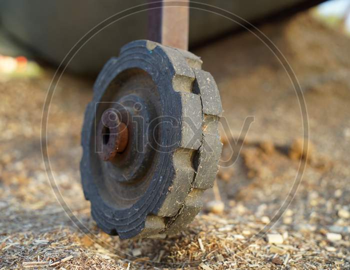 Round Black Wheel Of Fodder Cleaning Machine In Old Rustic Stage. Black Wheel Closeup Shot.