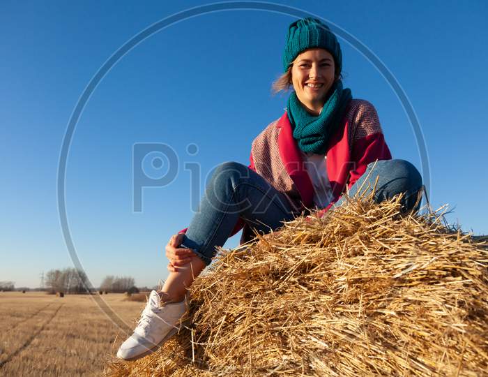 Beautiful Modern Urban Young Woman Wearing  Blue Knitting Hat, Pink Coat And Jeans. Trendy Teenage Girl In Autumn Outdoors.