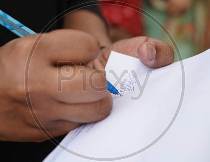 Close Up Image Of A Man Signing A Document With Selective Focus On Pen Tip