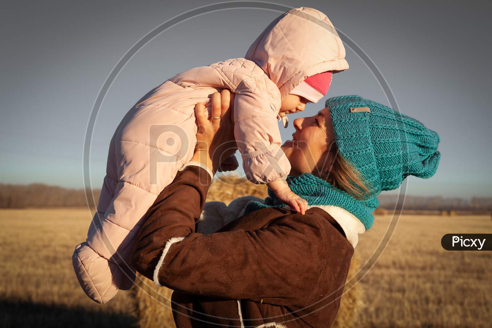 The Concept Of Livestyle  Outdoor In Autumn. Close Up Of A Young Woman Student In A Warm Autumn Clothes With Baby Looking Funny, Smilling, Posing And Playing With Daughter  On The  Field Stack