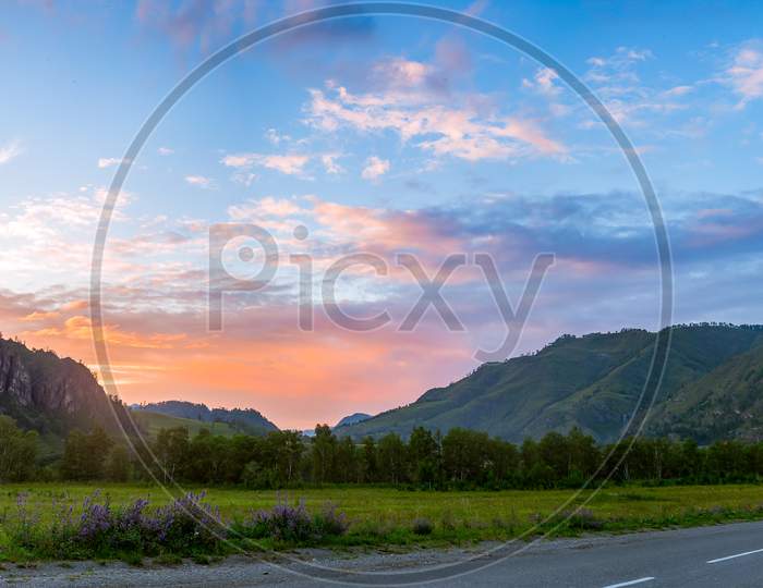 Beautiful Mountains Of The Altai And A Winding Road  At The End Of A Summer Day With A Clear Blue Sky