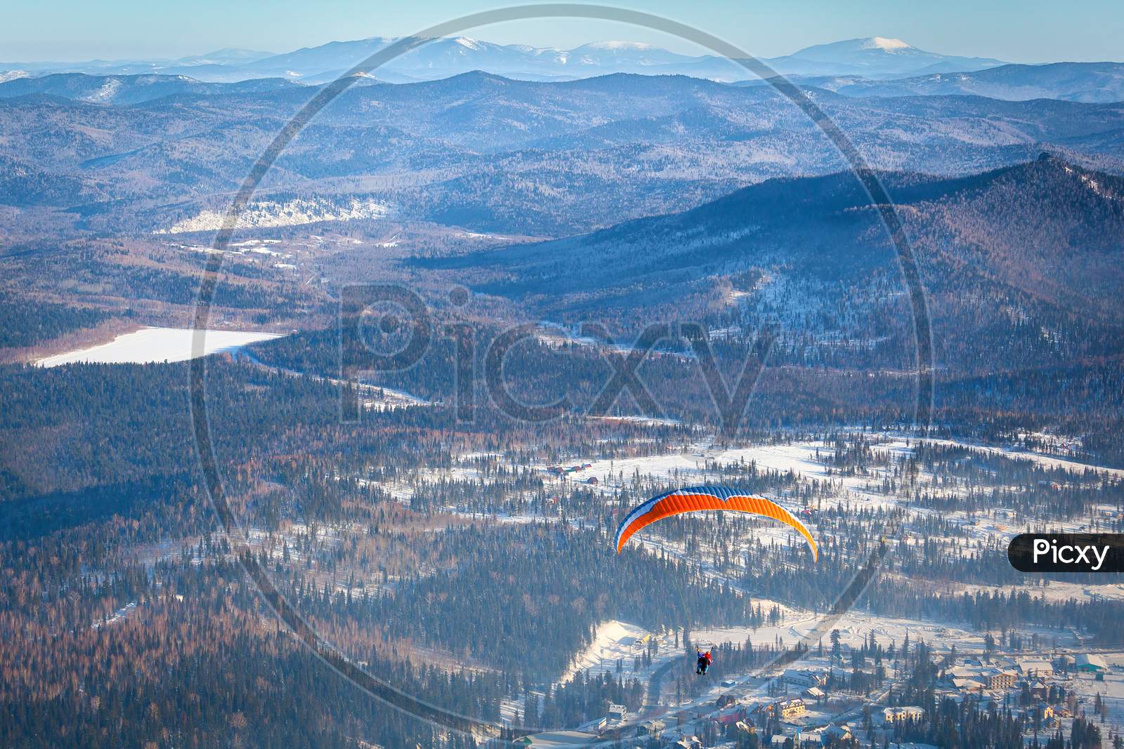 Man Flies With An Orange Parachute