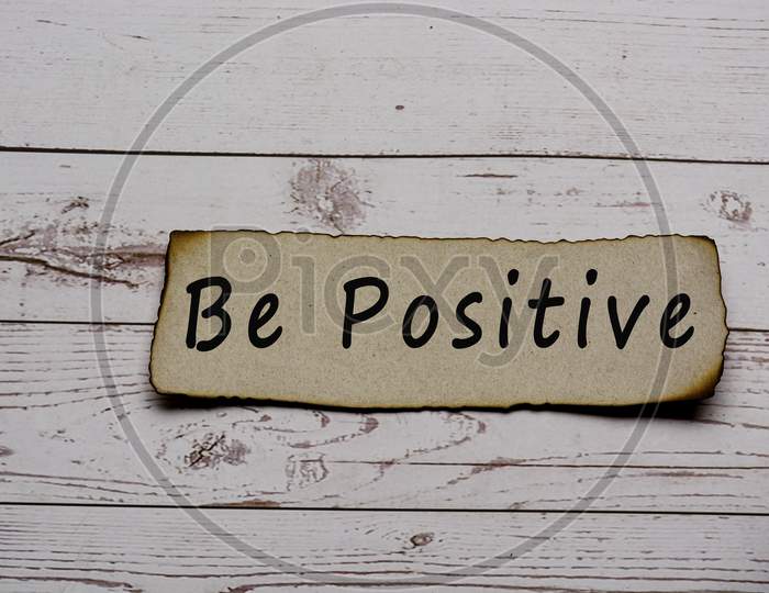 Be Positive Text On Burnt Edge Brown Paper