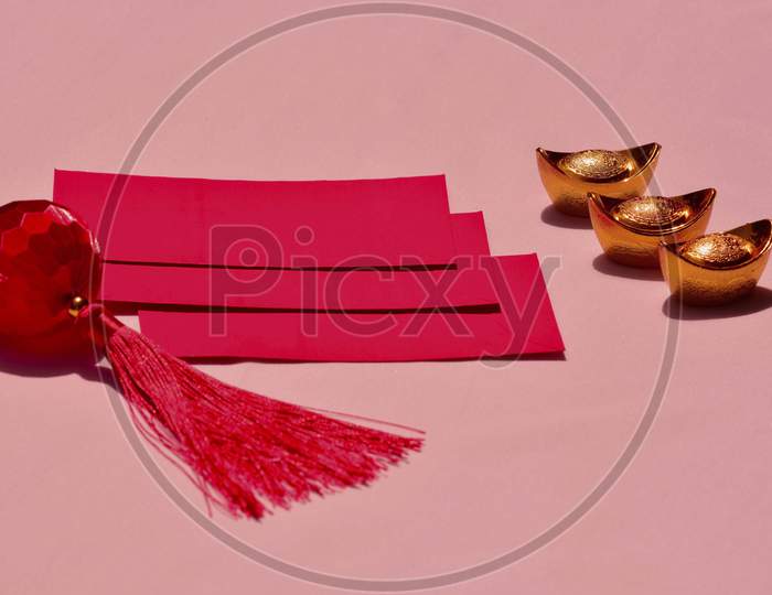 Chinese New Year Spring Festival Decorations Red Packet And Gold Ingots On Pink Background. Chinese Translation : Good Fortune, Good Luck, Wealth, And Money Flow.