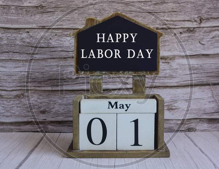 Text On Chalkboard And White Cube Block On Wooden Table - Happy Labour Day