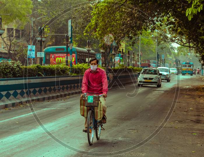 PERSON CYCLING ON THE ROADS OF KOLKATA, WEST BENGAL.