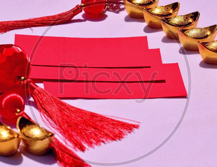 Chinese New Year Spring Festival Decorations Red Packet And Gold Ingots On Pink Background. Chinese Translation : Good Fortune, Good Luck, Wealth, And Money Flow.
