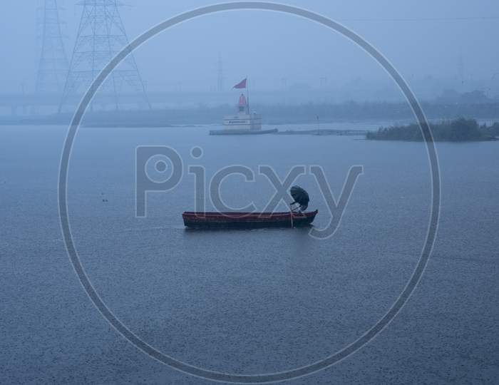 A Boat Man Crossing River During Rainfall