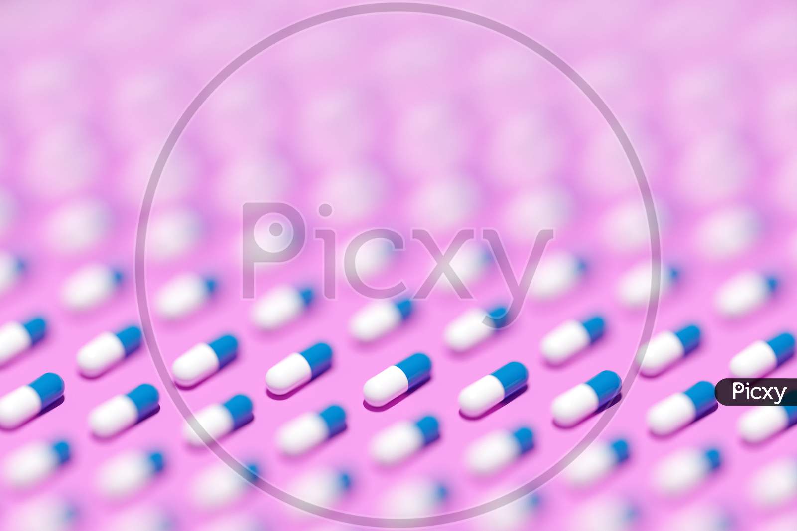 3D Illustration White -  Blue  Capsules, Tablets With Medicine In Even Rows On A Pink  Background. Capsule Medicine