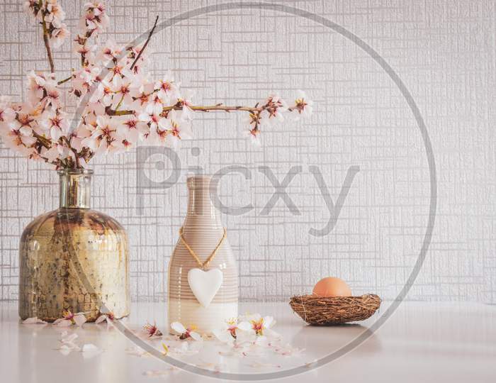 Spring Vibrant White Table Set Up With Daisies, Easter Egg, Heart Pendant And Copypaste Background