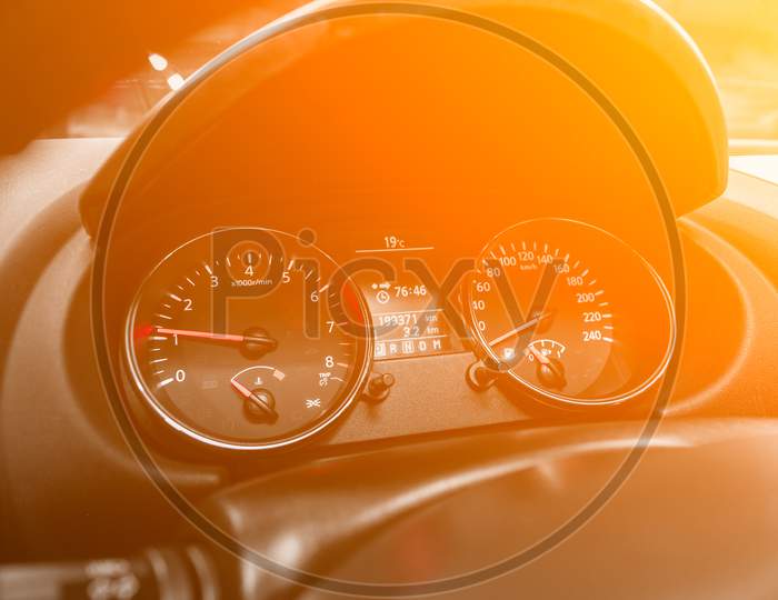 Dashboard Of The Car Is Illuminated By Bright Illumination. Speedometer, Circle Tachometer, Oil And Fuel Level Under The Yellow And Orange Neon Color