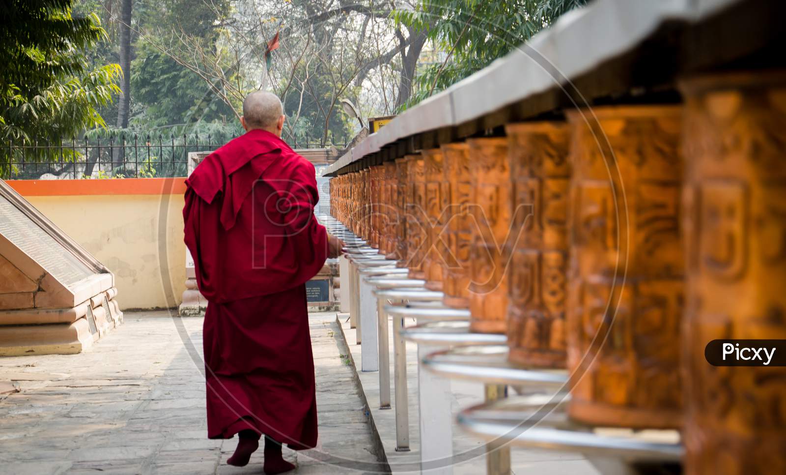 A Monk With Prayer Wheels In A Bhuddisht Temple