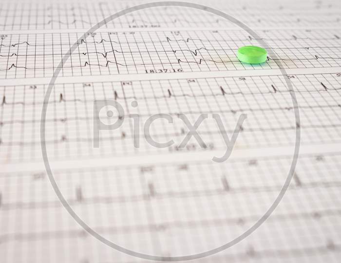 Colored Pills On An Electrocardiogram Paper. Medications For Cardiac Patients. Heartbeats Recorded On Paper. Selective Focus.