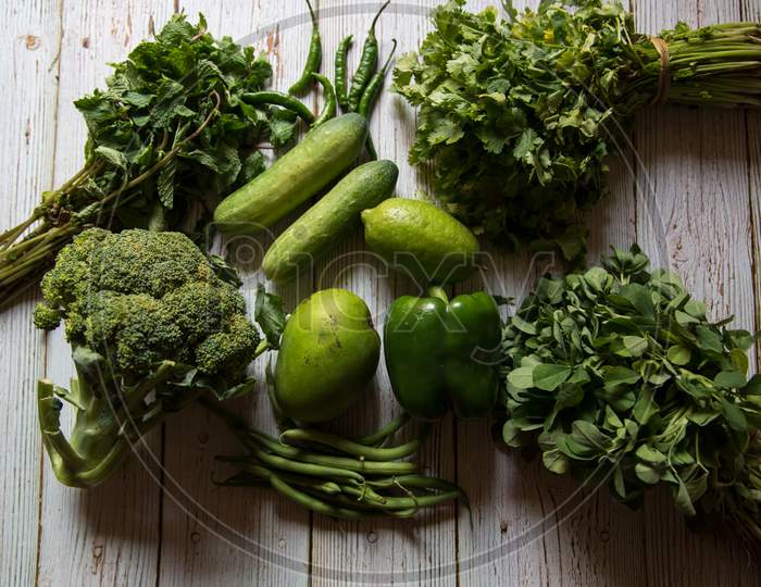 View from above of fresh vegetables on wooden background.