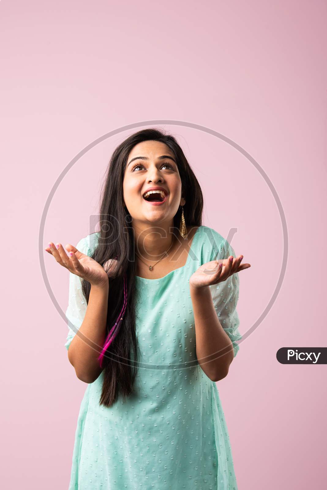 Pretty Indian Asian Young Woman With Joyful Expressions As Glitter Falling On Her Head Against Pink