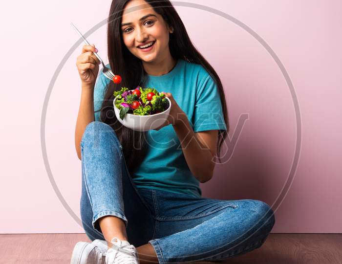 Indian Asian Young Beautiful Woman Eating Fresh Green Salad In A Bowl