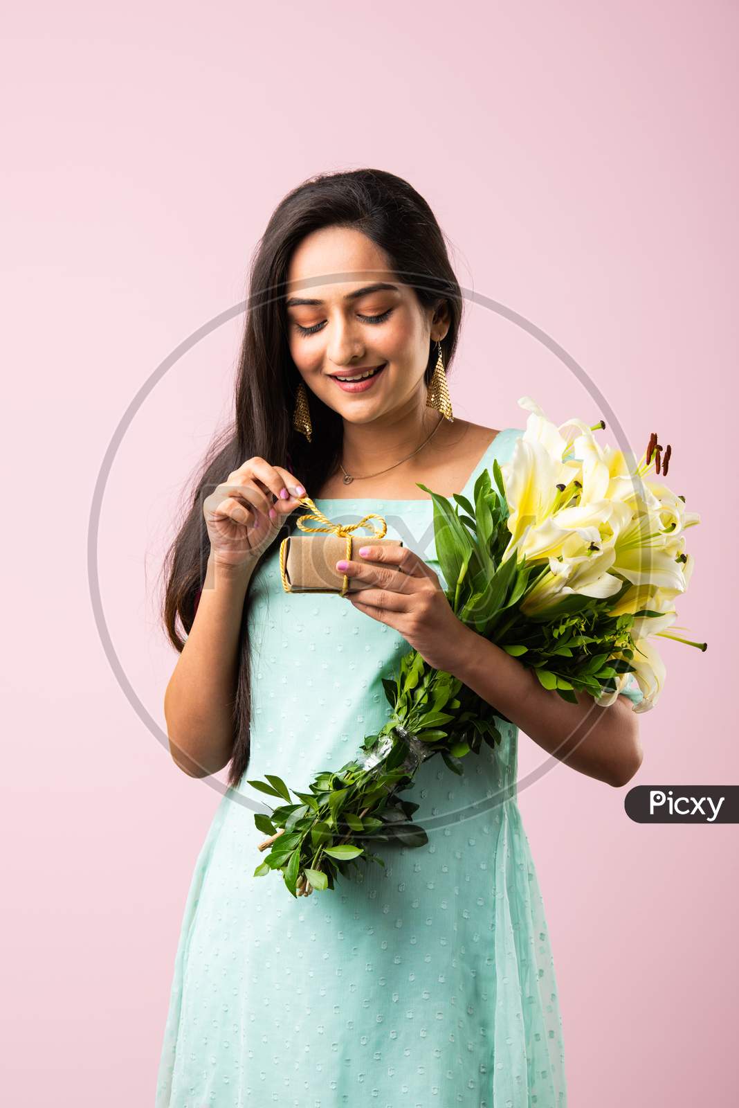 Indian Pretty Girl Opens Gift While Holding Flower Bouquet