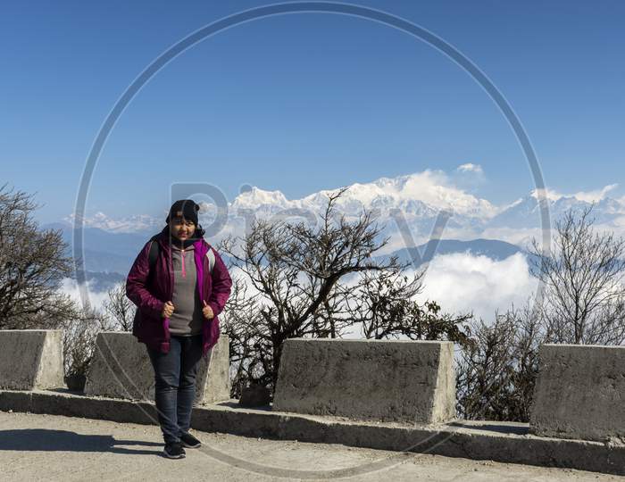 A Female Traveler Standing At A View Point And Enjoying The Beauty Of Himalyan Range.