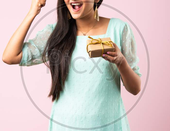 Indian Girl Or Woman With Gift Box Against Pink Background