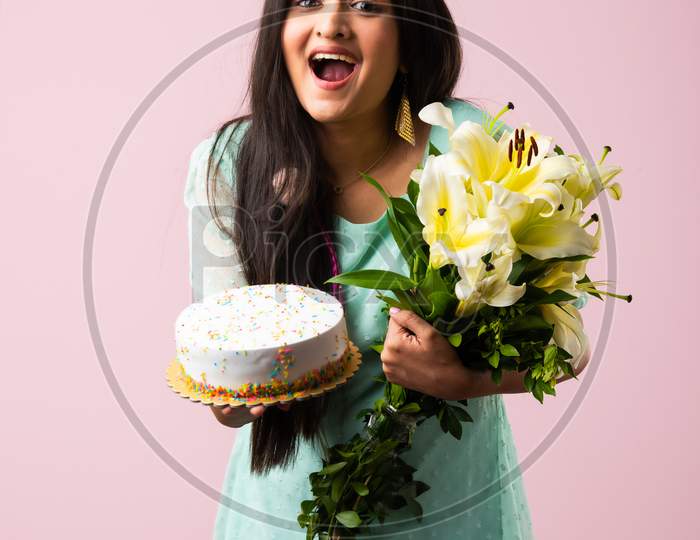 Happy Indian Asian Girl Standing With Flowers Bouquet And Cake