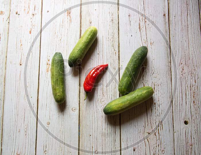 Top view of raw red chilli  and cucumbers