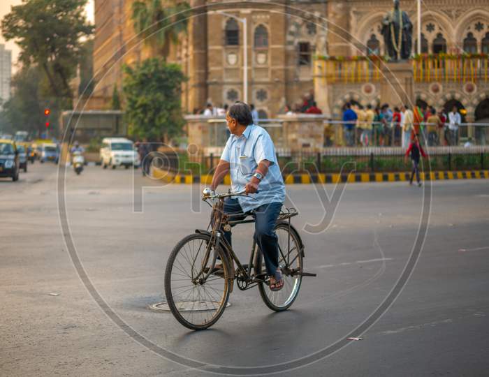 An Elderly Man Ridding A Bicyle Near Cst Station In South Mumbai