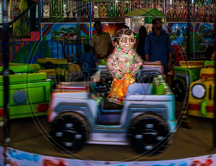 Indian Kids Enjoying Carousel Ride In A Open Car At Amusement Park