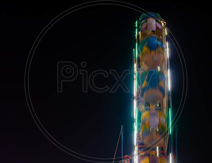 A Colourful Moving Giant Wheel At Amusement Park Illuminated