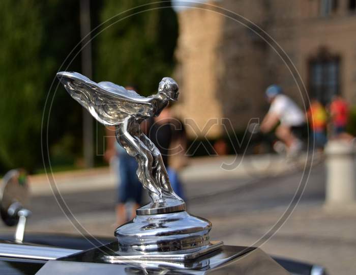 Car emblem made with the figure of a woman with wings in take-off position to fly
