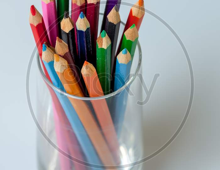 A Group Of Coloured Pencils In A Glass Tumbler