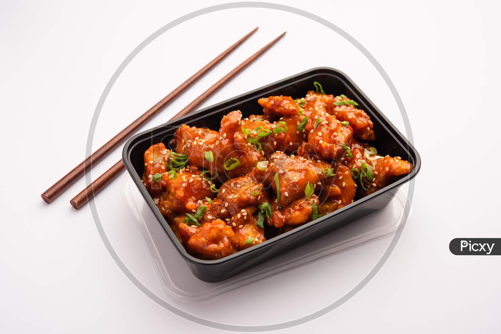 Online Food Delivery Concept In India - Tasty Chilli Chicken Packed In A Black Plastic Box