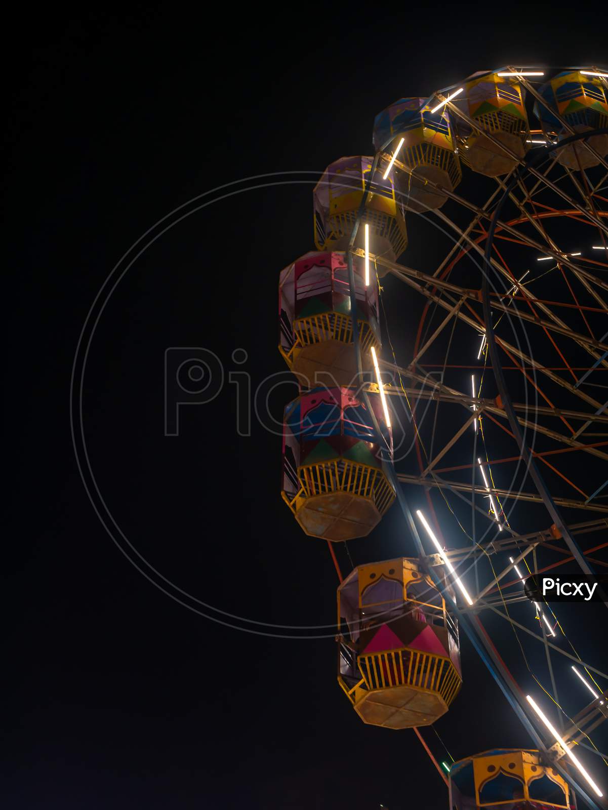 A Colourful Giant Wheel At Amusement Park Illuminated At Night