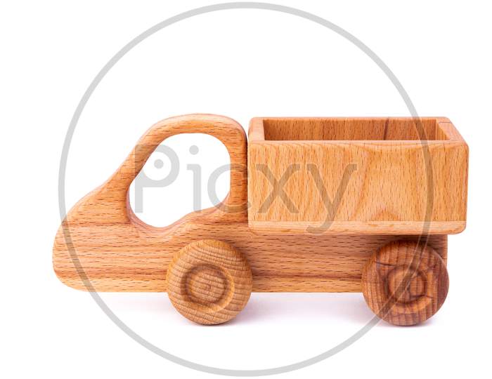 Photo Of A Wooden Car  Of Beech. Toy Made Of Wood Retro Truck On A White Isolated Background. A Toy For Entertaining Children And Resting Parents