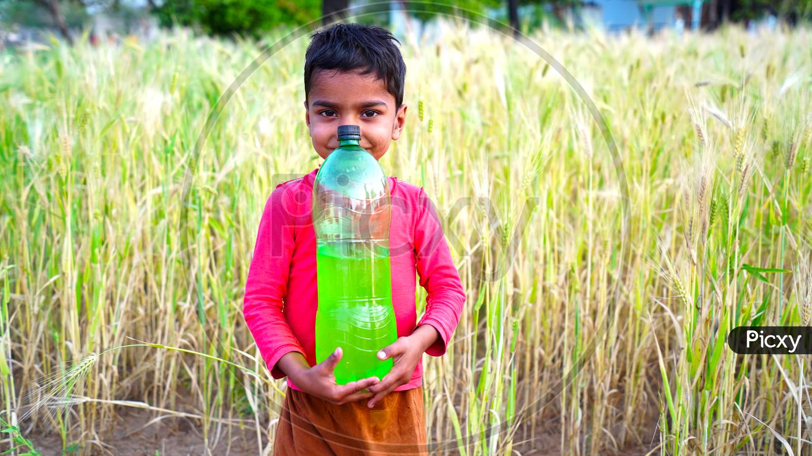 Indian boy carrying water bottle hi-res stock photography and