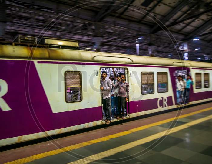 Unidentified Passengers Standing On The Door Of Moving Local Train In Mumbai