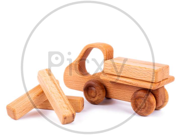 Close-Up Children'S Toy Made Of Natural Wood In The Form Of A Dump Truck  With Wooden Blocks In The Form Of Cargo On A White Isolated Background. Studio Photography. Eco-Friendly Toy For Parents And Children