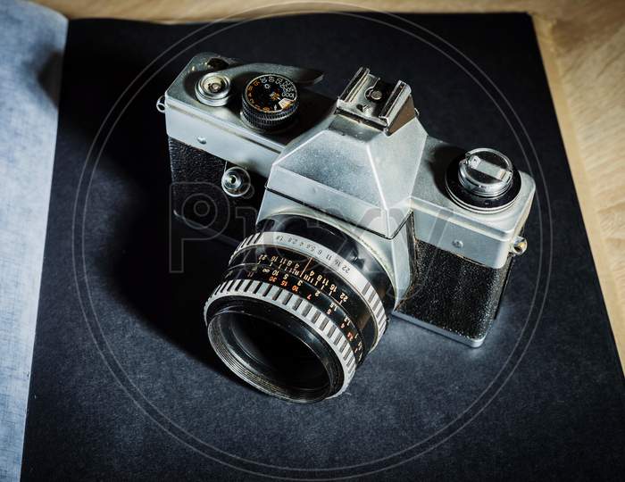 Old film retro camera  on a black photo album