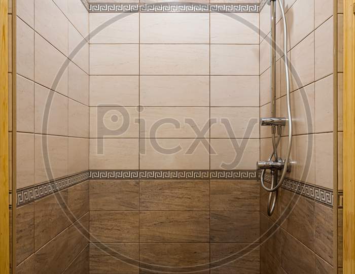 Bathroom In A Traditional Style With Brown And Beige Walls.Minimalist Shower Room With Hotel Sauna