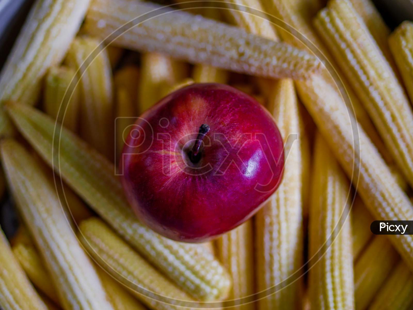 Fresh Apple And Baby Corns Arranged In A Basket