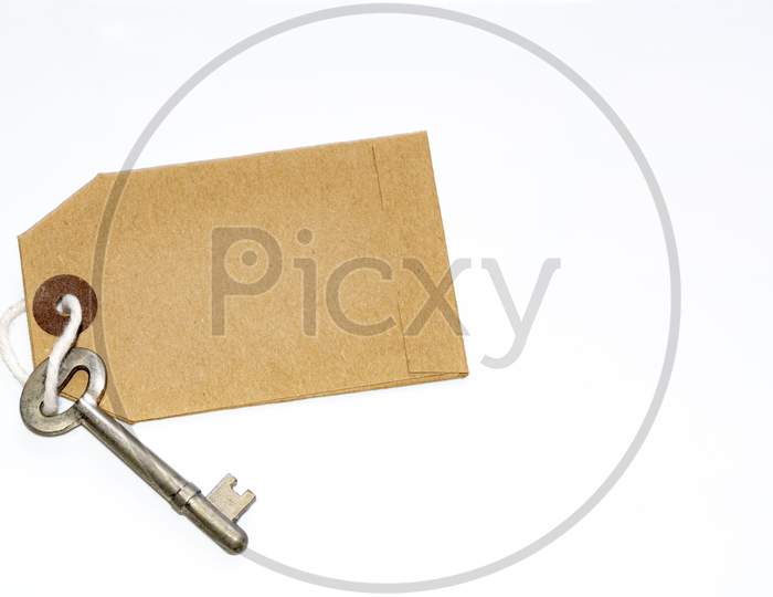 Key And Brown Paper Tag On White Background