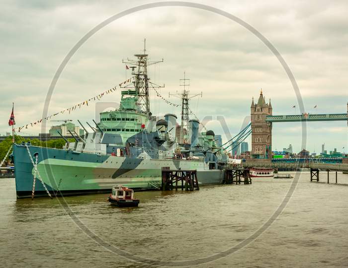 British Battleship In Rive Thames With Tower Bridge In The Background
