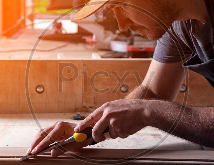 Close Up Of Young  Man Builder Wearing In A Plaid Shirt   Treating A Wooden Product With A Chisel In The Workshop, Close-Up