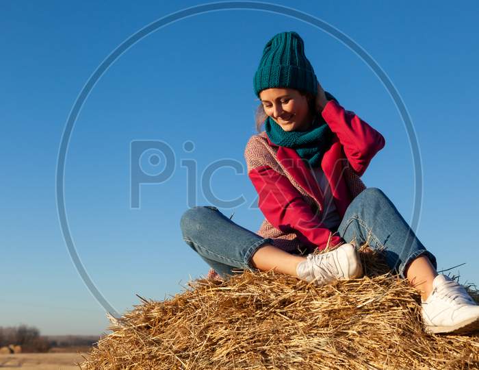 Beautiful Modern Urban Young Woman Wearing  Blue Knitting Hat, Pink Coat And Jeans. Trendy Teenage Girl In Autumn Outdoors.