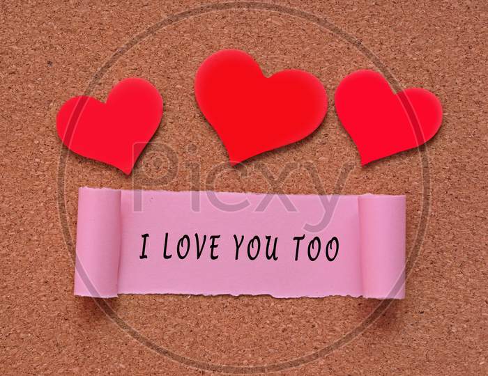 I Love You Too Label On Torn Paper With Heart Shape On Red Background