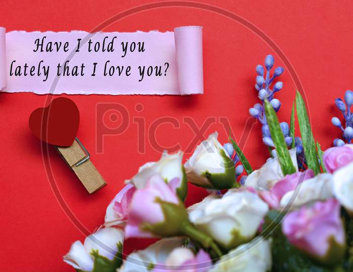 Text Label On Torn Paper With Flowers And Heart Shape Clothespin On Red Background