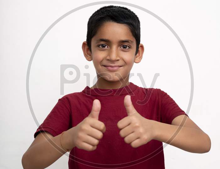 Young Indian Kid Showing Thumbs Up Into The Camera While Smiling. Small Kid Education Concept.