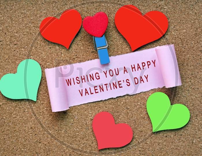 Wishing You A Happy Valentine'S Day Label On Torn Paper With Colorful Heart Shape On Wooden Background. Valentine'S Day Concept.