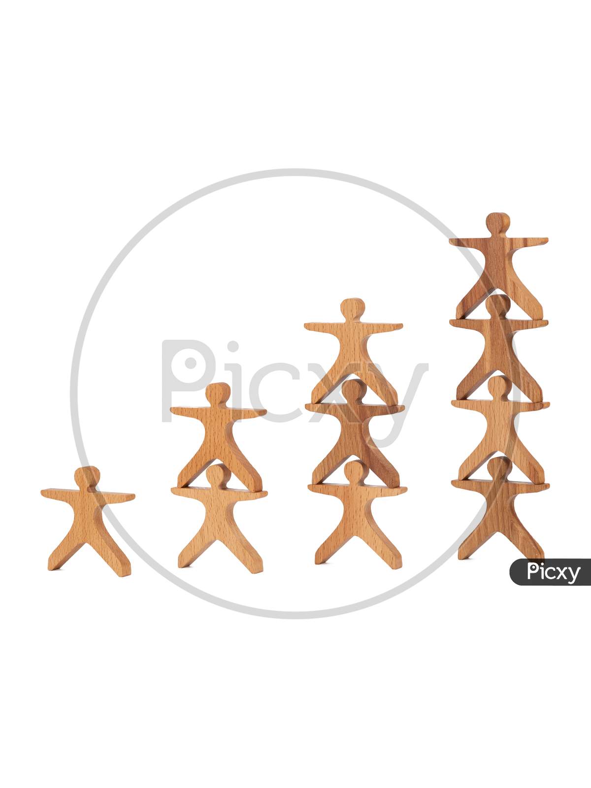 Close-Up Of A Children'S Toy Made Of Natural Wood In The Form Of Little People Stand Pyramid On A White Isolated Background. Eco-Friendly Toy For Parents And Children
