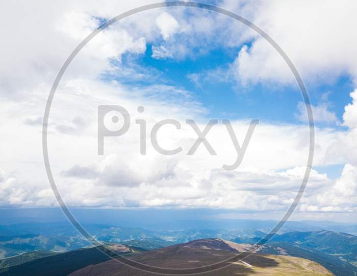 Ultra Wide Panorama Of Skyline. Green Mountains Covered With Forest On The Blue Sky Background.  Amazing View On Green Mountains From A Viewpoint
